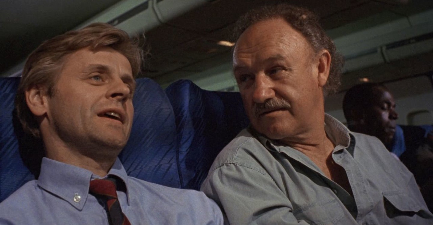 Mikhail Baryshnikov and Gene Hackman sit next to each other on a plane in Company Business