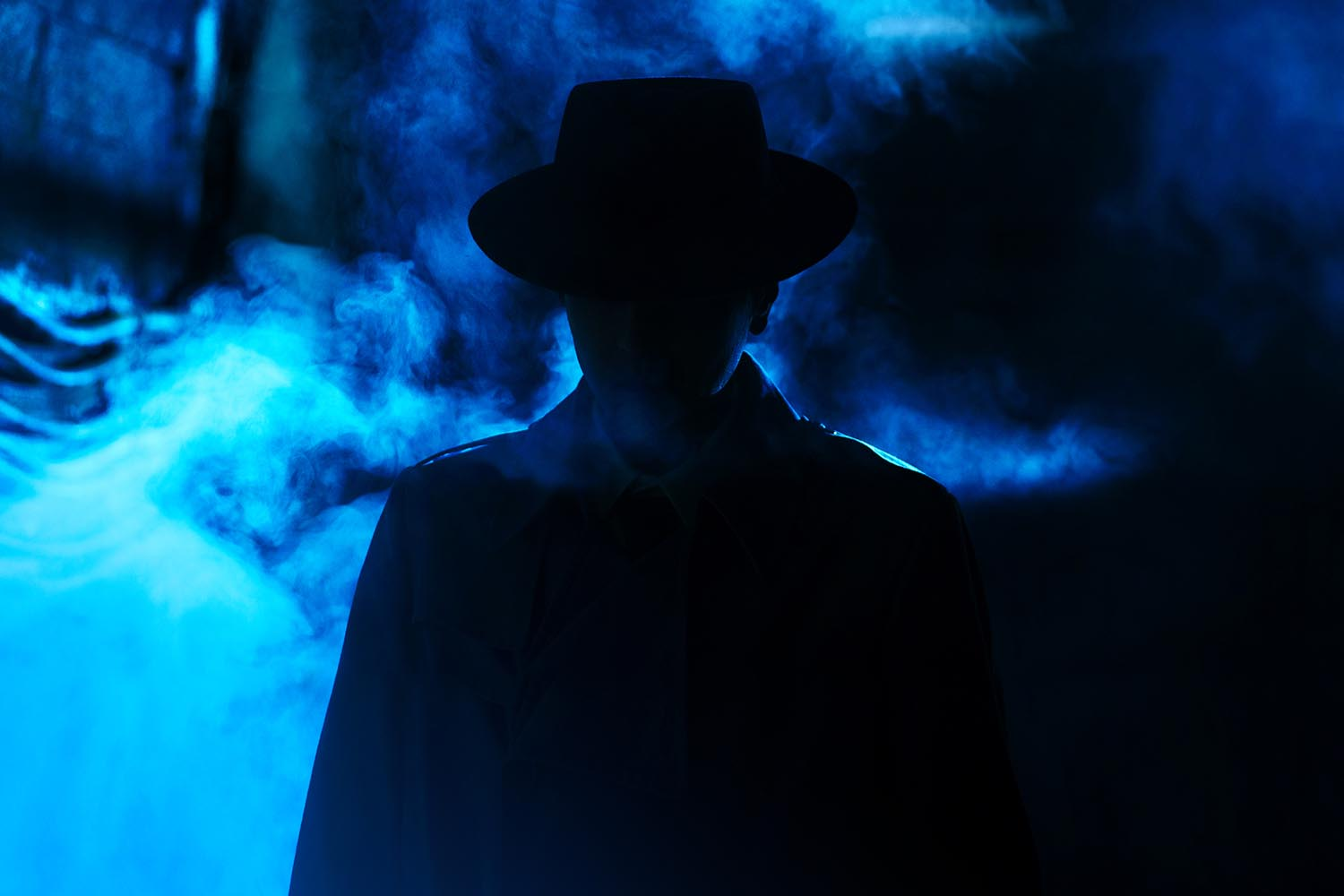 A man standing in fog wearing a coat and a hat in a blue-tinted image from Resurrection