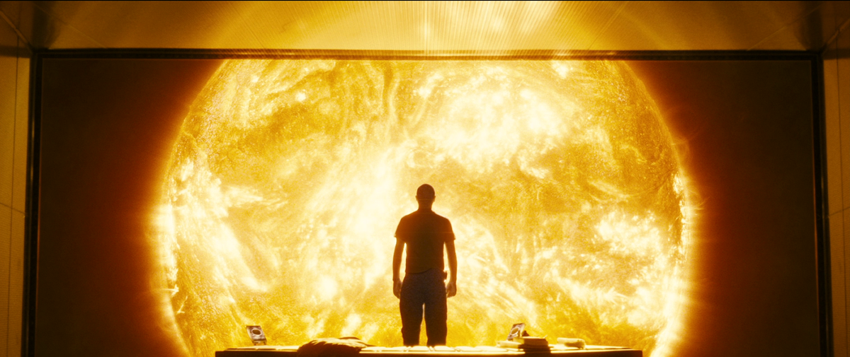 A man is silhouetted as he stares at the sun through a window in Sunshine