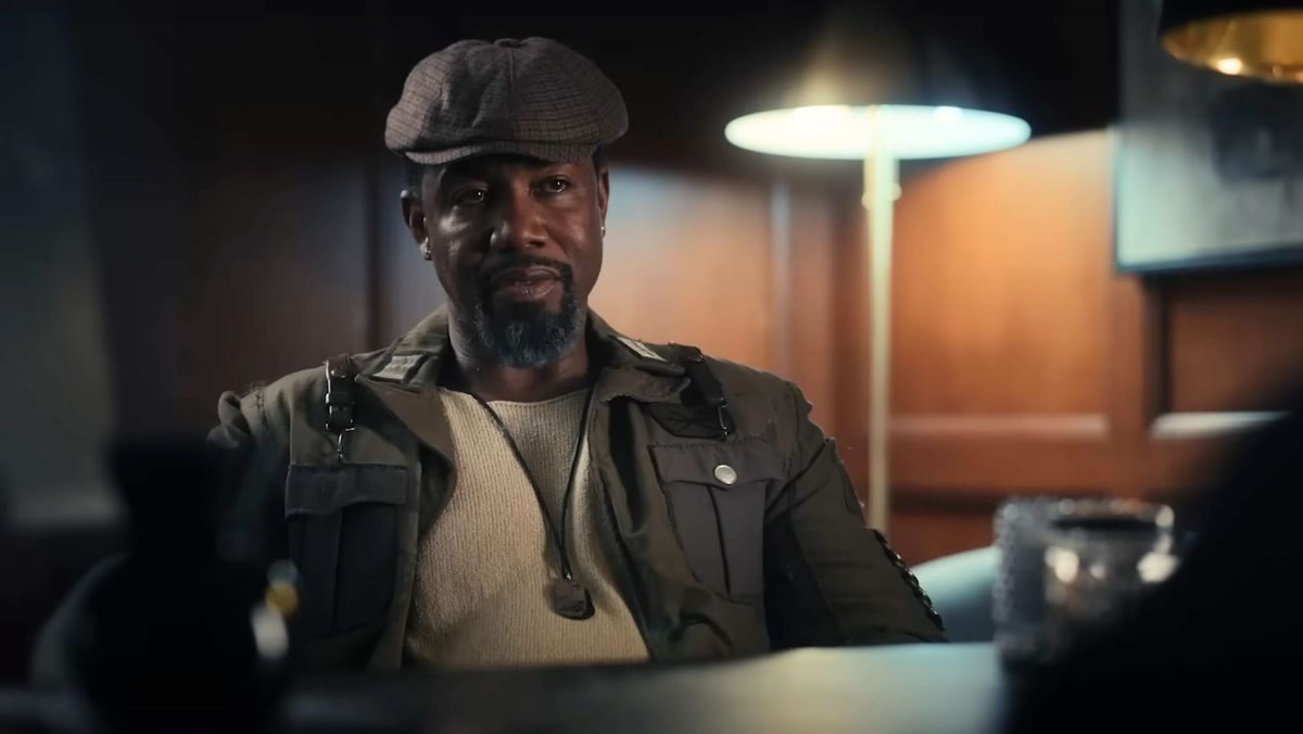 Michael Jai White sits at a desk in Trouble Man