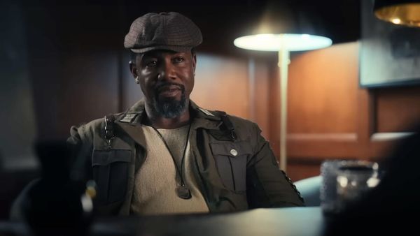Michael Jai White sits at a desk in Trouble Man