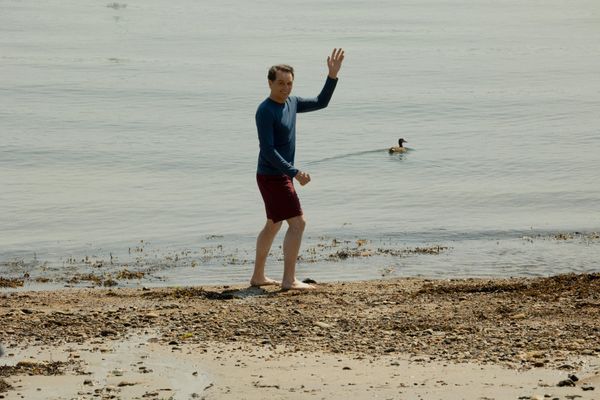 Matthew Rhys gives a goofy wave on the beach in Widow's Bay