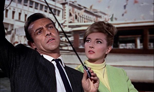 In From Russia With Love, Sean Connery inspects a reel of small film as Daniela Bianchi looks on