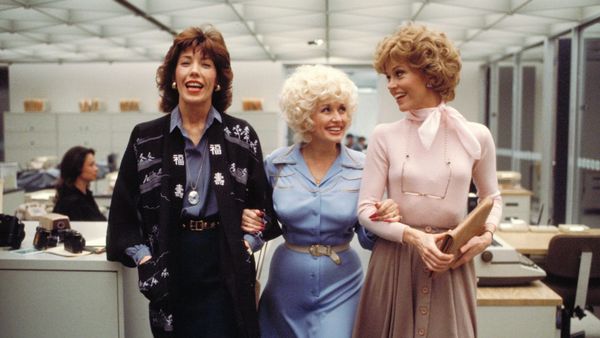 Lily Tomlin, Dolly Parton, and Jane Fonda walk arm-in-arm through the office in 9 to 5