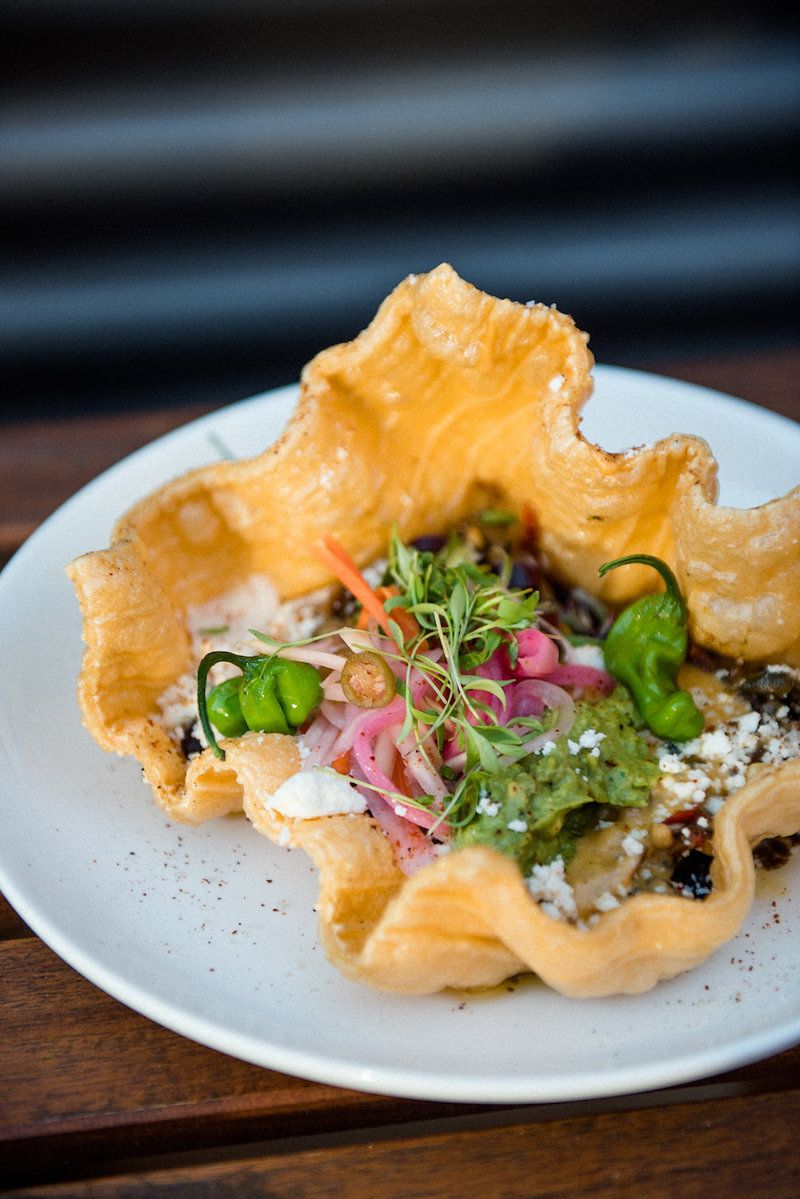 Adzuki bean dip with avocado purée and pickled red onion on crispy rice cracker. 