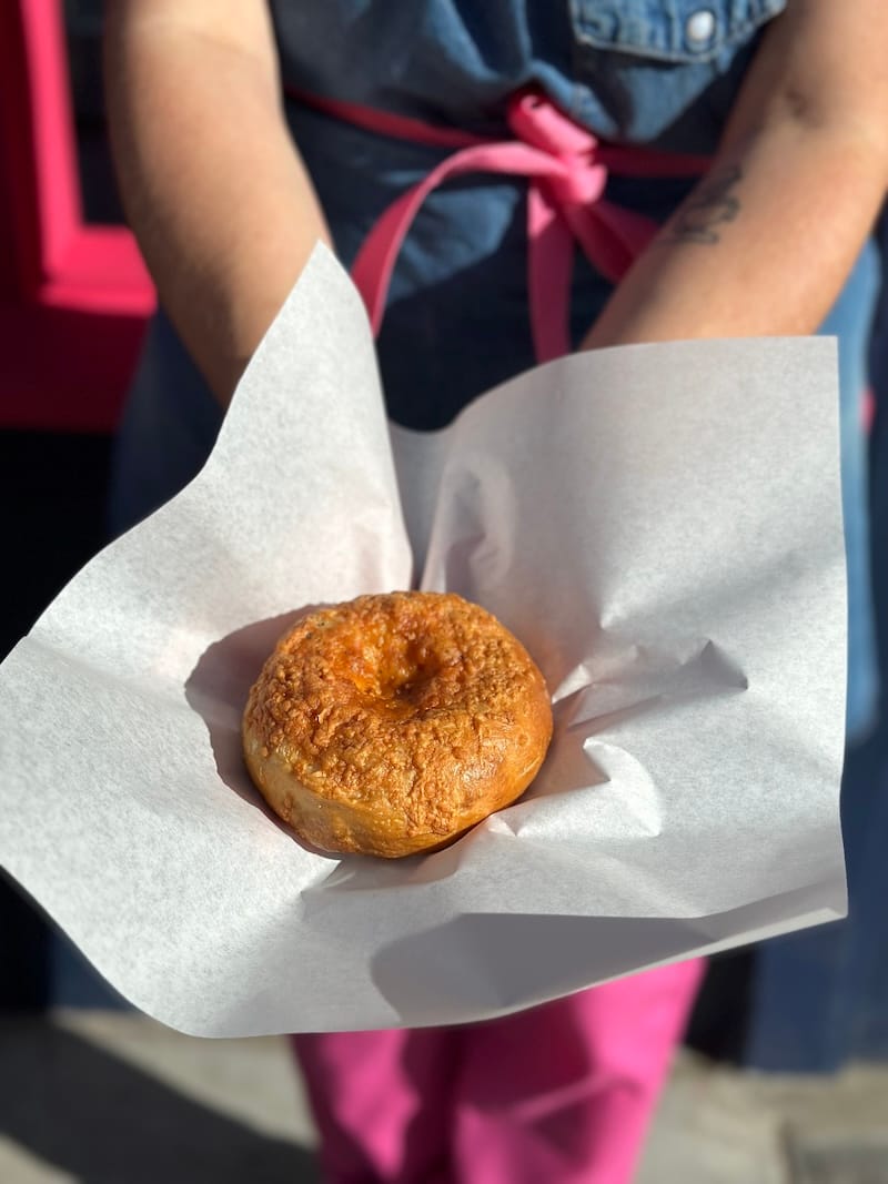 an Asiago-rosemary bagel held in wax paper