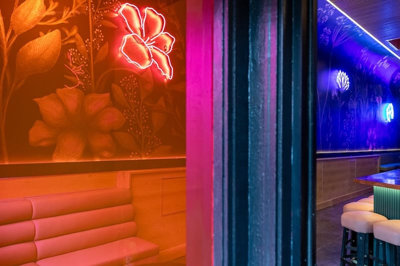 Custom neon flowers from Neon Works installed over the floral wallpaper. Photo: Ashley Ann Photos.