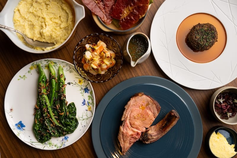 A Southern-inspired spread at Prelude, including hominy grits, spot prawn tartare, and a dry-aged pork chop. Photo: Adahlia Cole.