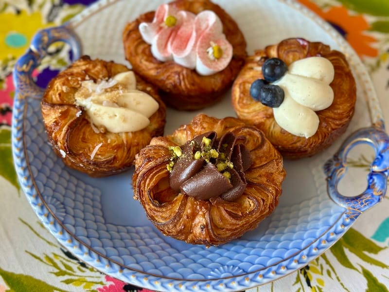 Clockwise, from center back: strawberry rhubarb with chamomile meringue, blueberry lemon, Dubai chocolate, and coconut cream pie kouign amann from Starter Bakery. Photo: © tablehopper.com.