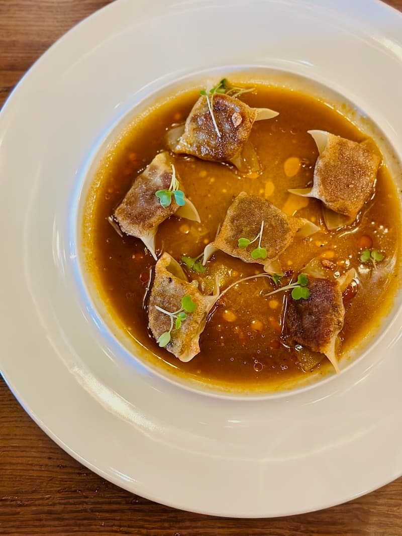 The “bò kho” dumplings with Snake River Farms wagyu, bone marrow, and lemongrass-tomato jus. Photo: © tablehopper.com.