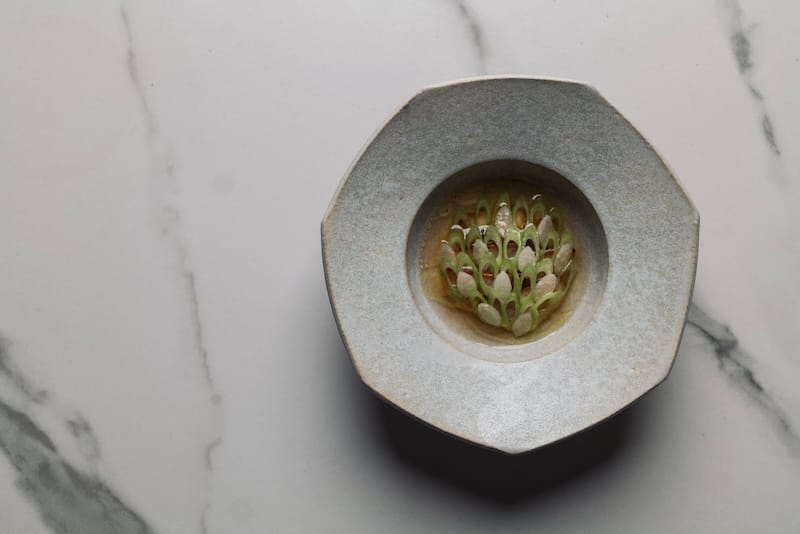 Sinigang (a savory and sour Filipino soup) made with dry-aged beef broth seasoned with tamarind, barbecued abalone, yam leaf, and pickled daikon. Photo: Jim Sullivan.
