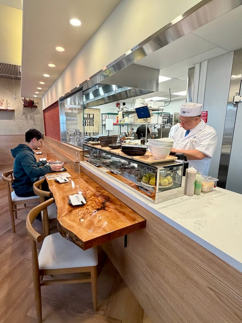 The raw-edge wood dining counter flanks the kitchen. Photo: © tablehopper.com.