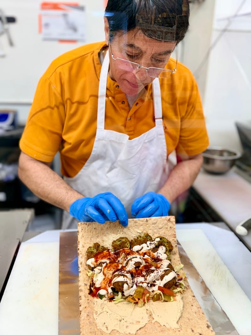 Falafelland chef-owner Billy Alabsi rolling up a falafel wrap that is a dream for both of us. Photo: © tablehopper.com.