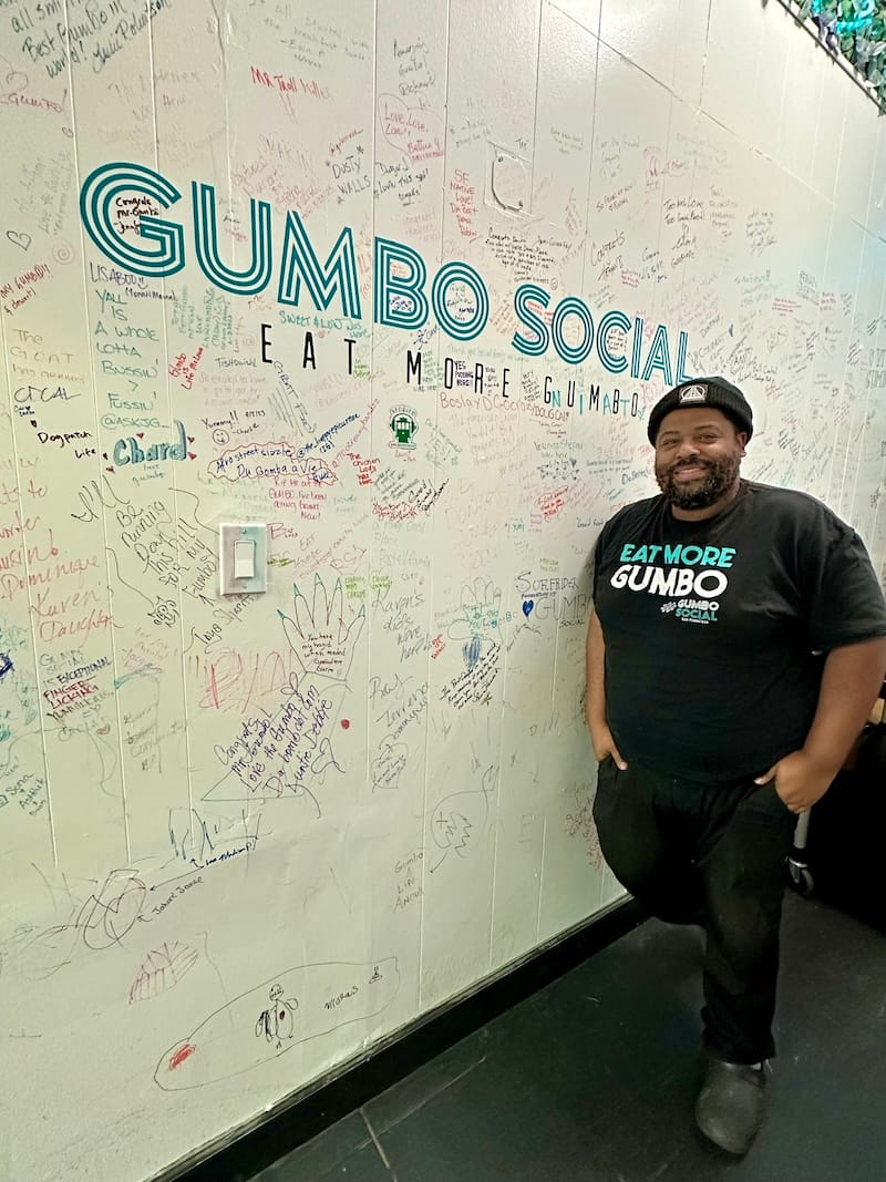 Gumbo Social’s chef-owner Dontaye Ball at his wall of notes from friends and customers. Photo: © tablehopper.com.