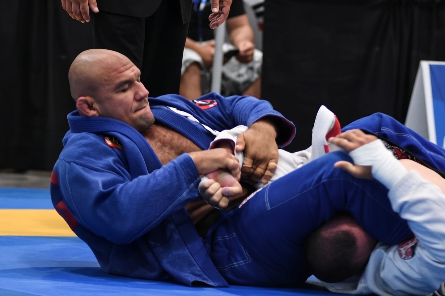 Roberto “Cyborg” Abreu, in a blue gi, works from his back at an IBJJF tournament