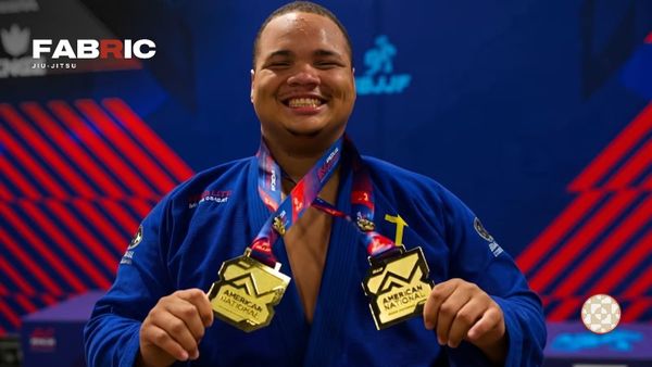 Thierry Felipe in a blue gi, smiling and holding up two American Nationals gold medals
