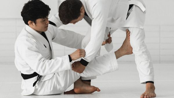 Thalison Soares in the gi, working from a seated guard
