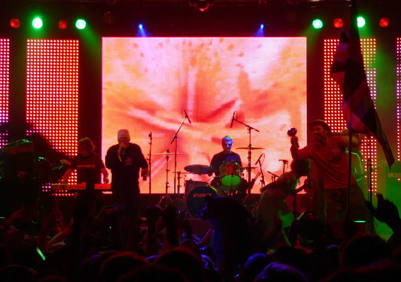 Happy Mondays performing in front of a large glowing video screen