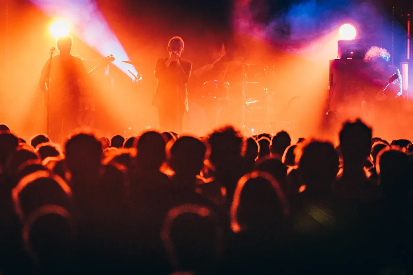The Jesus and Mary Chain on stage, silhouetted in orange and red light above a crowd