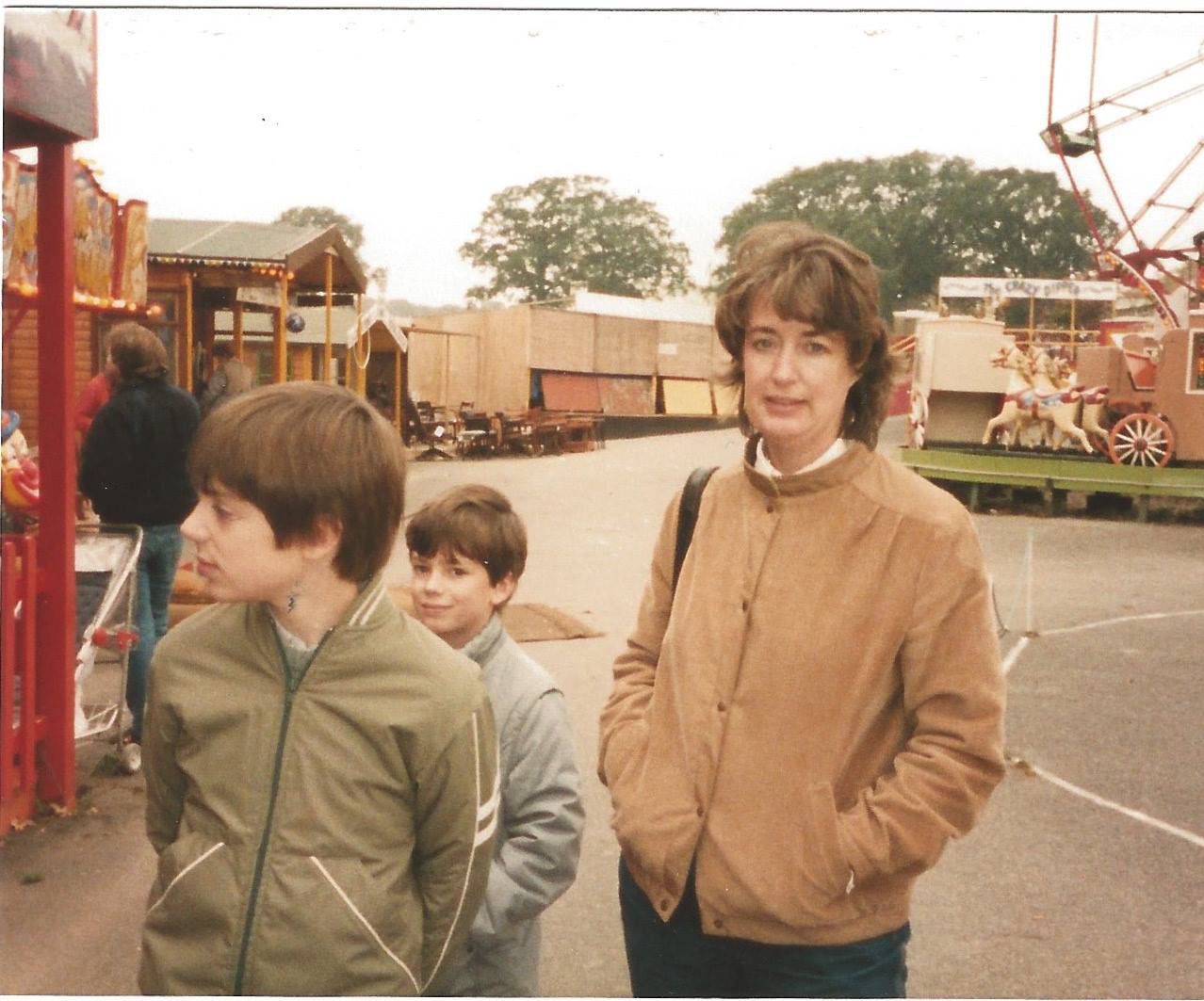 A photograph of Mum when she was in her late 30s maybe, which would make me about 10 and my brother about 8. We are at some godforsaken "attraction" somewhere in southern England. There is a lot of concrete on the ground and the sky is purest white. There are stalls (sheds) and a ferris wheel of the sort you wouldn't be caught dead on. Mum looks directly into the camera as if to ask "are you really going to take a picture of this?" My brother looks not quite into the camera, but into the mid-distance with a vague and unreadable smile, as if he's taken one look at this dump and gone somewhere better in his mind. I ignore the camera altogether and look off to the left (my right), hands behind my back, with the air of Prince Charles walking down a line of factory workers while being told which kind of grommet each one tightens as their jobs have not yet been automated away by robots. There are some very 1980s British High Street jackets going on. And the hair is... interesting. This is the real, shit, brown and beige 1980s that we actually lived through rather than the technicolour vapourwave version that was dreamed up to sell to people who came along afterwards.