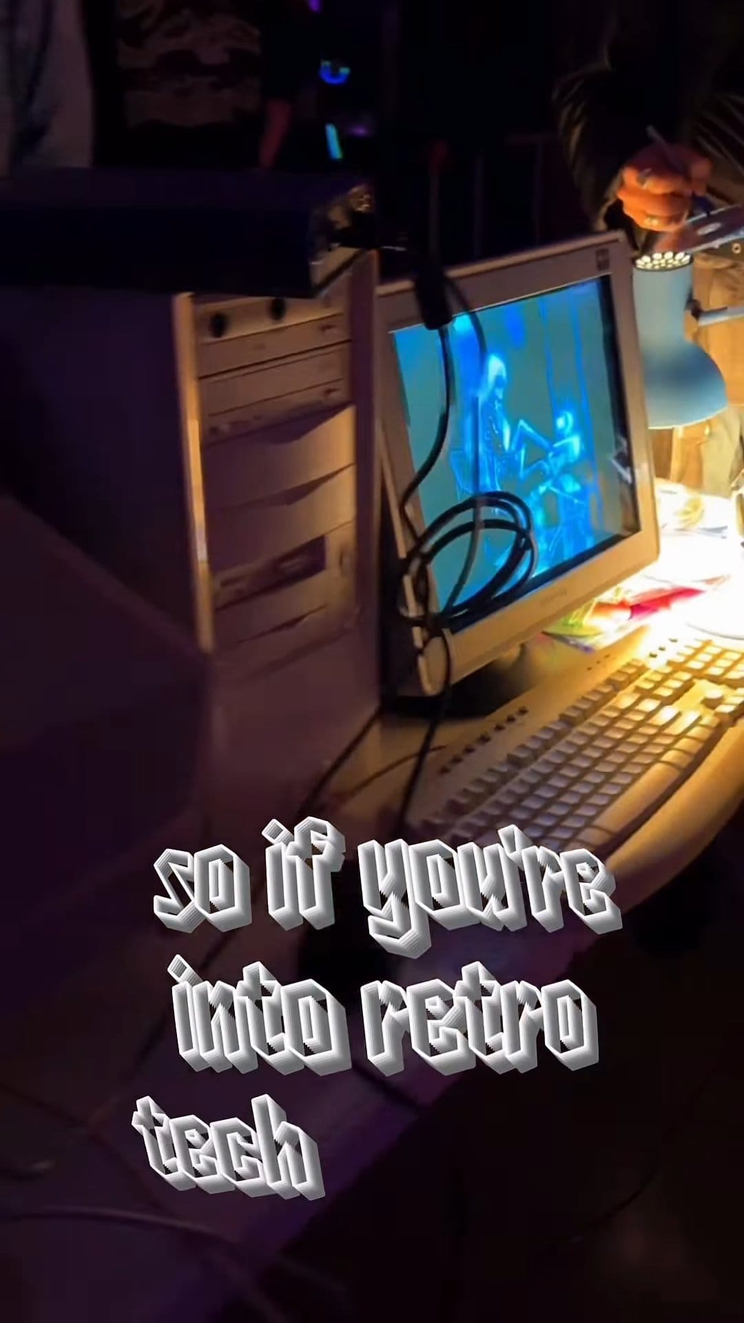 A CRT monitor and beige PC tower glowing under a desk lamp at DEAD INTERNET THEORY