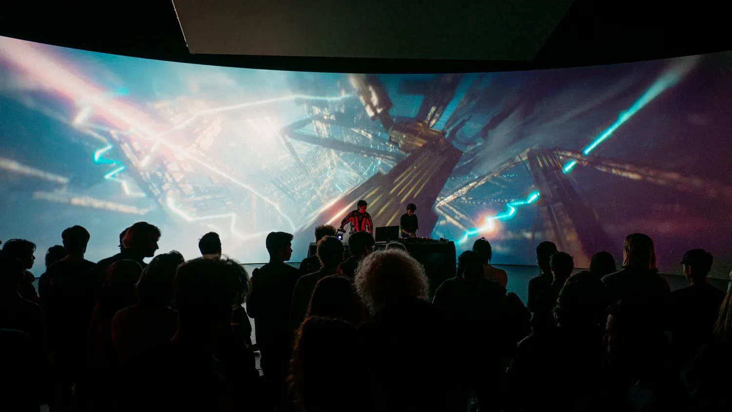 Performer silhouetted before a large projection of a simulated forest