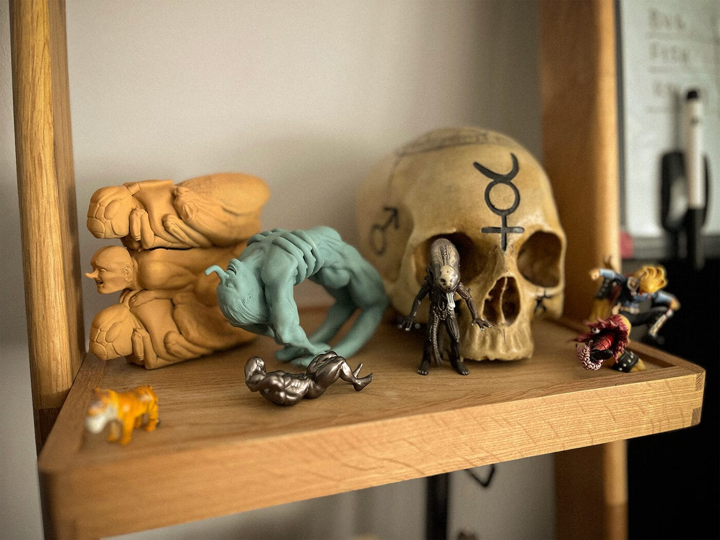 A shelf of Murlo's miniatures and sculptures, including a carved skull