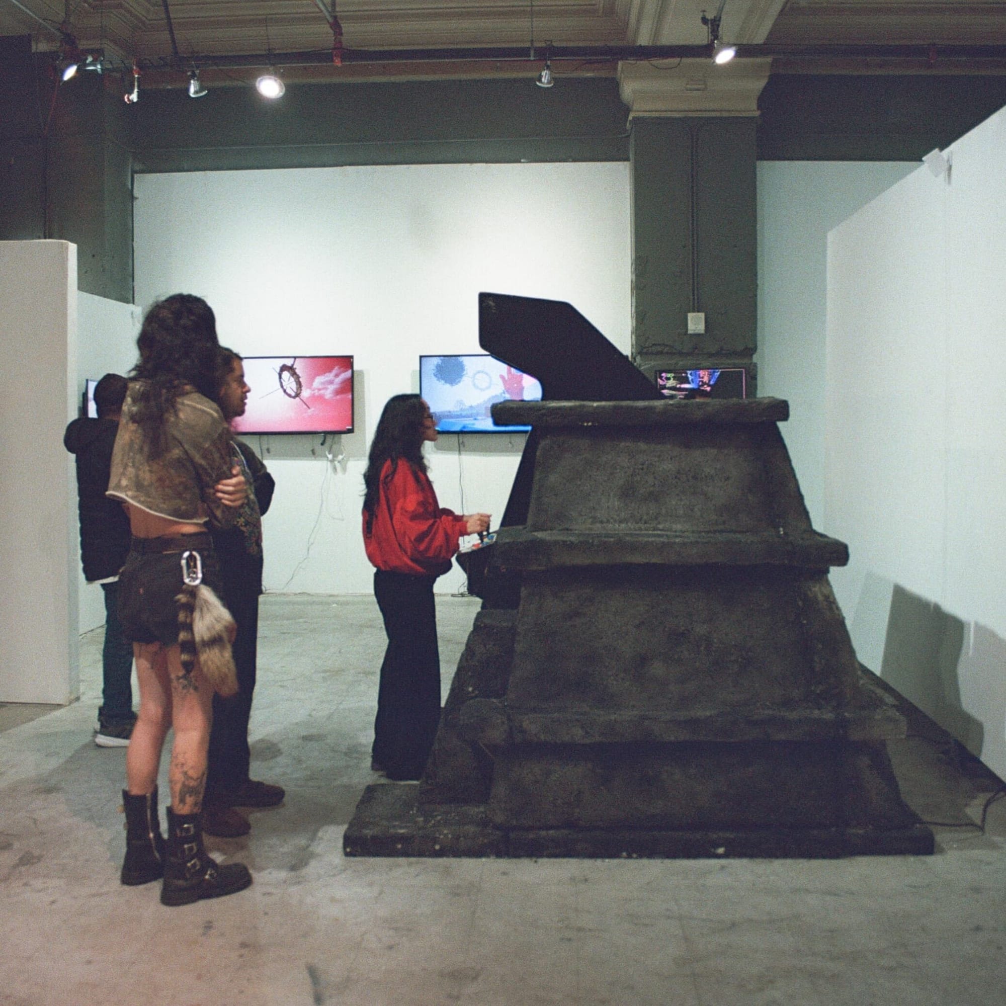 Visitors gather around the black pyramid housing the Ex-Nihilo ii arcade cabinet at 999