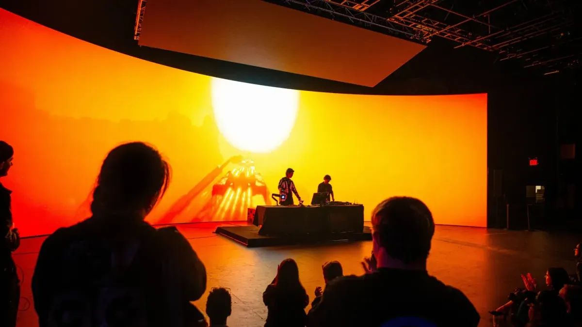Performer operating a sculptural camera controller in front of a projected synthetic forest
