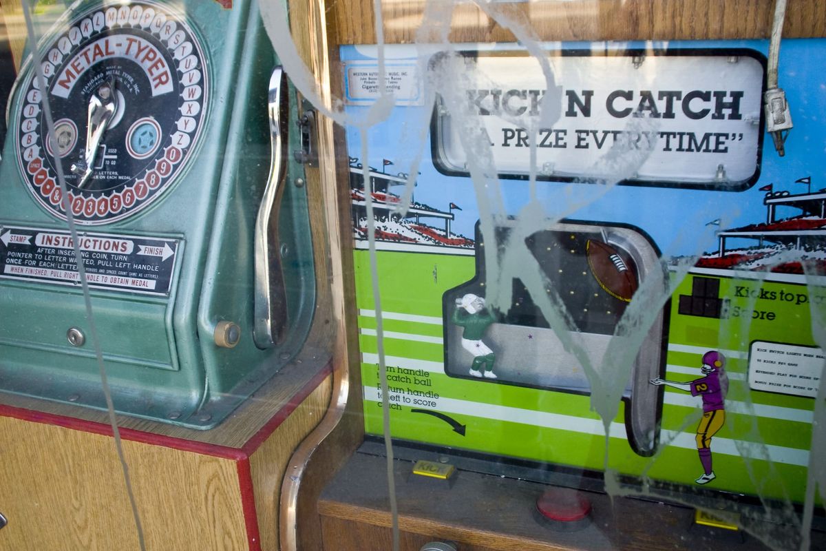 A green arcade crane machine reading KICK’N CATCH behind a distributor’s window in Chicago.