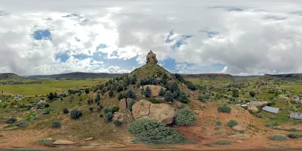 A wide 360-degree panorama of the Qiloane rock pinnacle under a clouded sky in Lesotho
