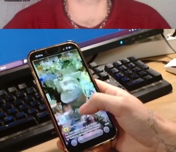 A hand holding a phone running Lackadaisical, the feed visibly glitching