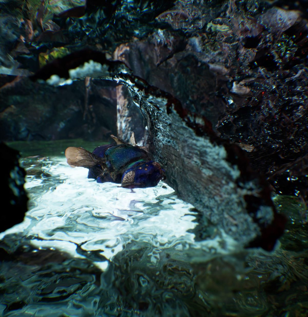 A figure lies in a luminous simulated swamp cave of moss, roots and pale water