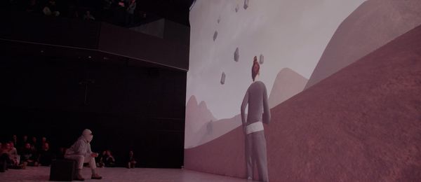 A performer stands before a vast projected hand in Letta Shtohryn's live XR performance Chuly? Chuly at Deep Space 8K