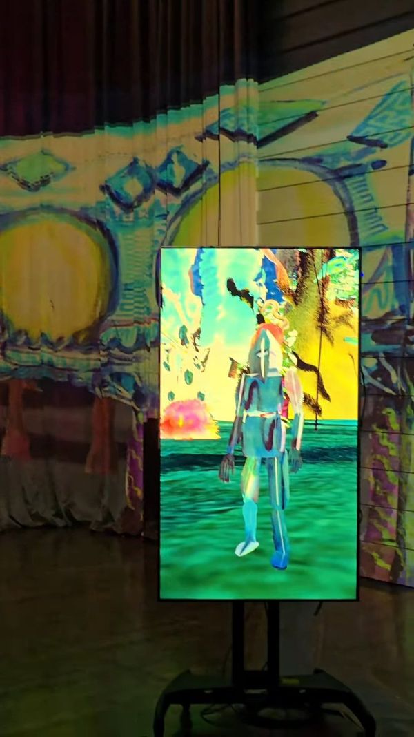 A watercolor-painted figure on a vertical screen in a dark exhibition room with projections