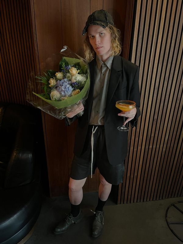 Ville Kallio holding a bouquet and a cocktail after receiving the Helsinki Artist of the Year award