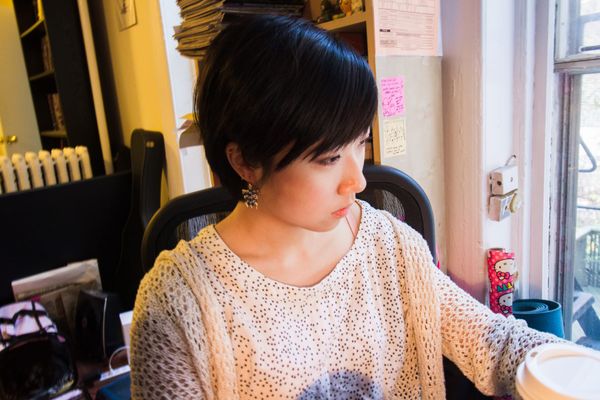 Jenny Jiao Hsia at her desk beside a sunny window, looking at her screen