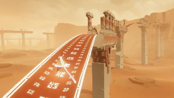 A robed figure crossing a vast sunlit desert of rippling sand dunes in Journey.