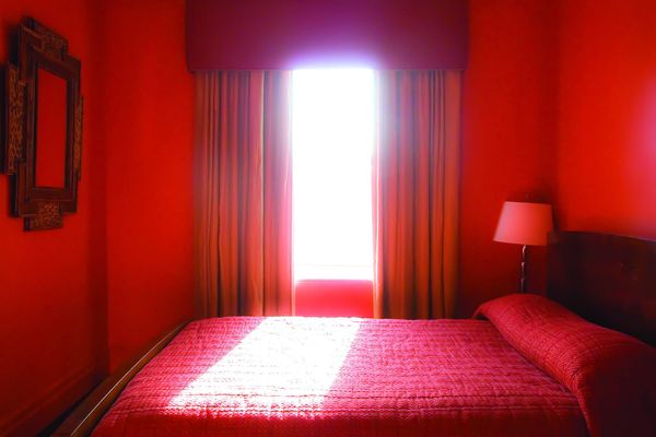 A red room with light pouring through a bright doorway