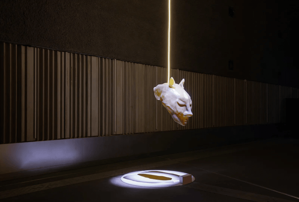 Keiken’s monumental fiberglass mask The Divine Puppeteer suspended in a gallery