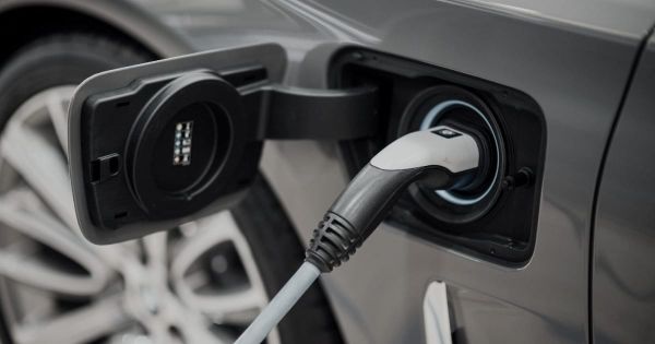  A close-up shot of a grey electric vehicle plugged into a charging station in Canada