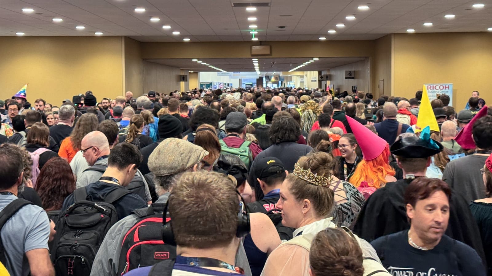 An enormous crowd, elbow to elbow, slowly moves through the convention center.