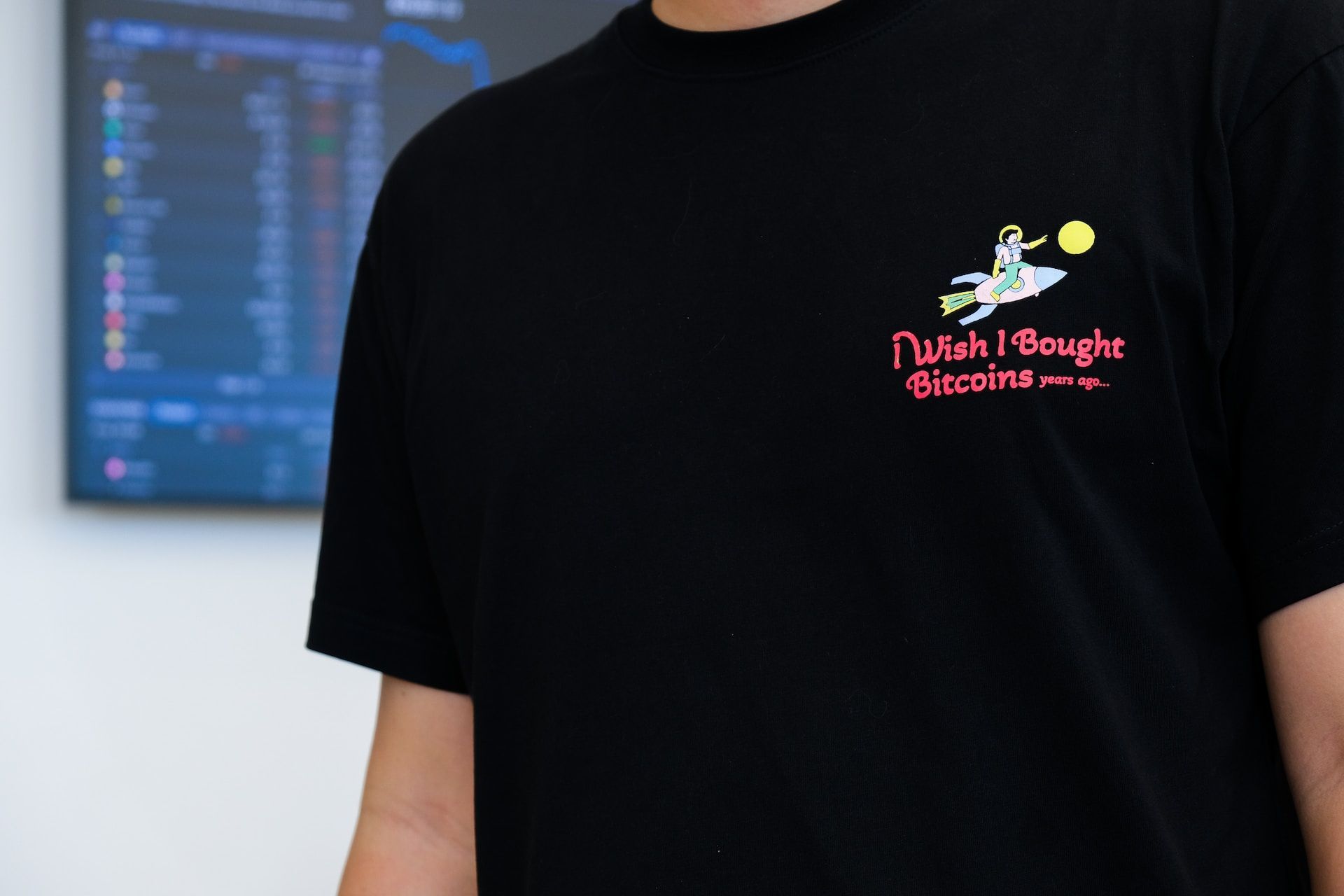 A man wearing an “I Wish I Bought Bitcoins Years Ago” shirt