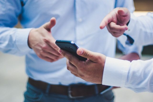 Man holding phone and pointing at it