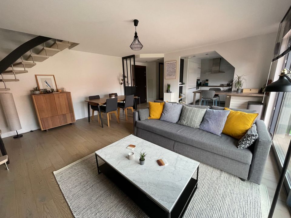 Salon et cuisine ouverte d'un appartement sous combles — bien choisir son logement commence par se poser les bonnes questions