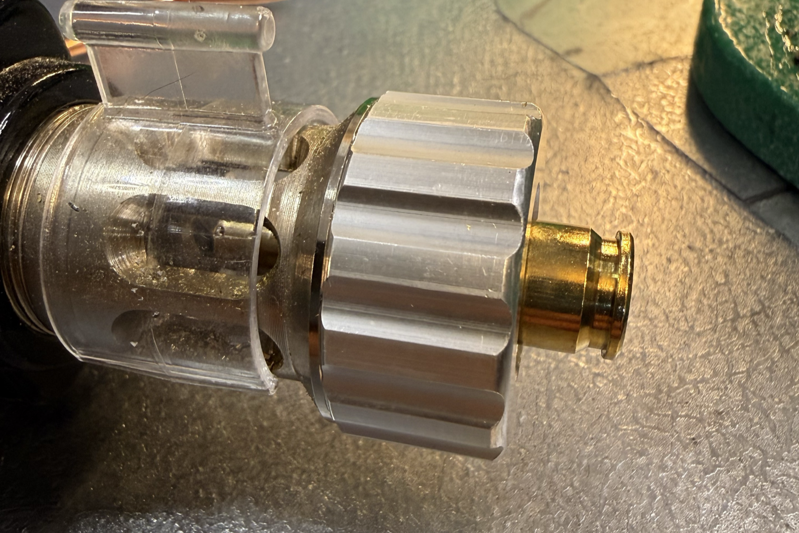 Close-up of a 6 BR case inserted into the bushing of a Lyman Brass Smith Case Trim Xpress, with the case head protruding.