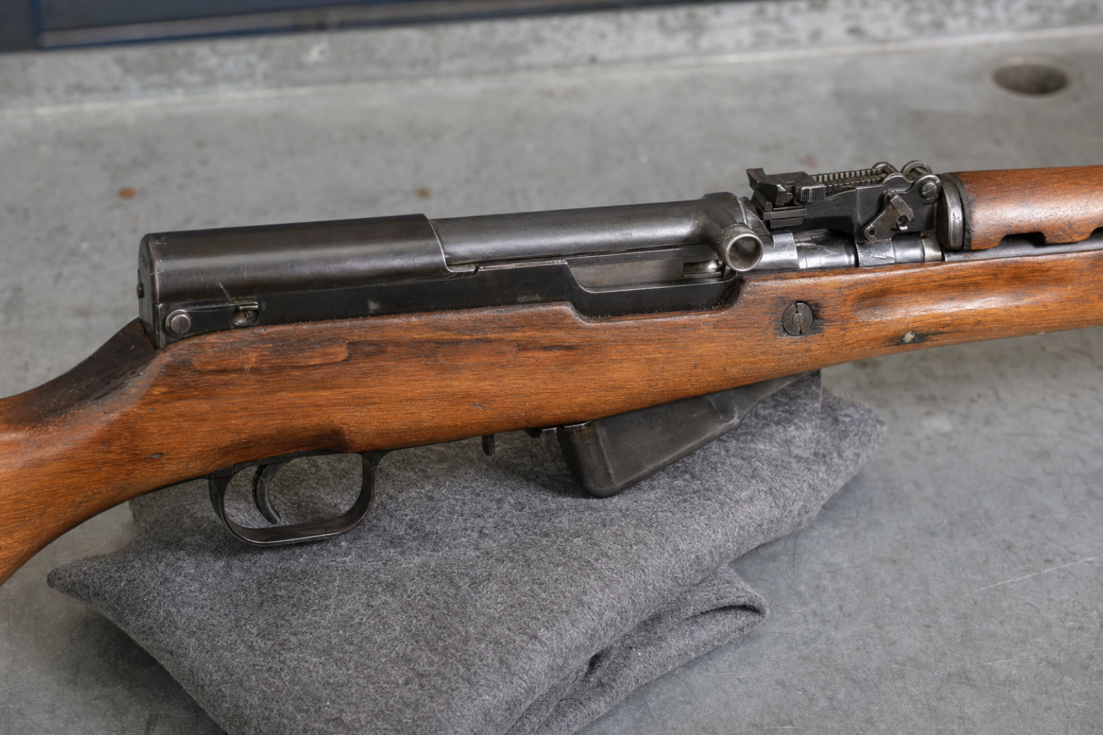 Close right-side view of an SKS receiver, short fixed magazine and trigger guard in a wooden stock.