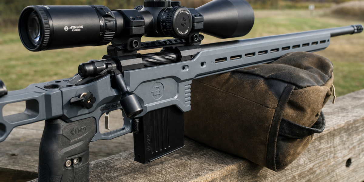 A grey Bergara Competition Elite chassis and black receiver in a close oblique view, supported on a bag at a timber range barricade.
