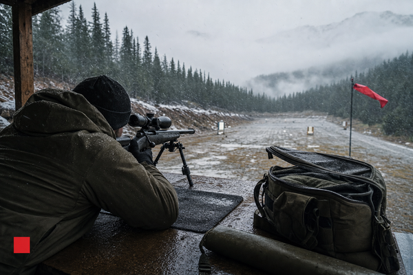 A cold Canadian range lane with a shooter testing gear in rough weather.