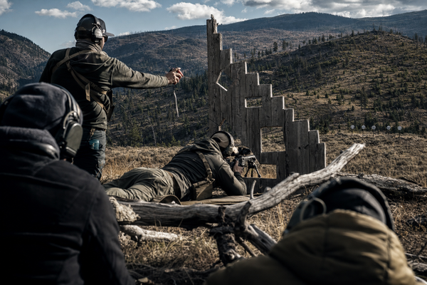 A BC mountain PRS stage with an anonymous squad, barricade prop, match timer, and distant steel targets.
